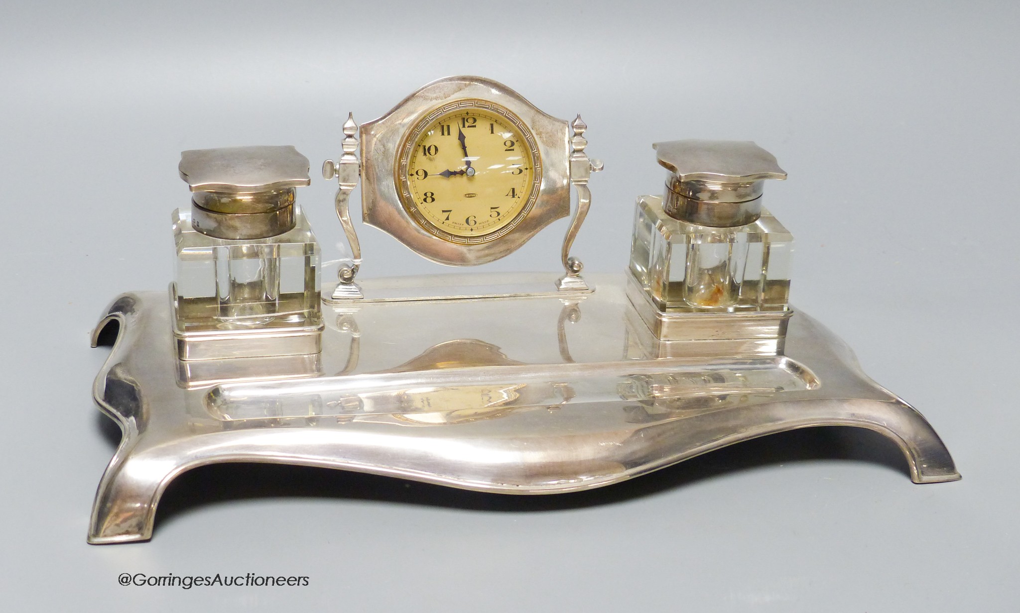 A George V silver desk standish with two silver topped inkwells and central timepiece, Robert Pringle & Sons, Birmingham 1928, 29.2cm